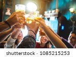Group of happy friends drinking and toasting beer at brewery bar restaurant - Friendship concept with young people having fun together at cool vintage pub - Focus on middle pint glass - High iso image