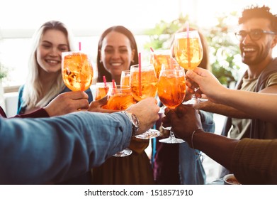 Group of happy friends drinking and toasting friends at a bar restaurant - Concept about young people having fun