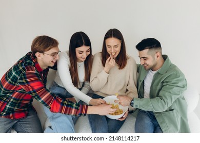 A Group Of Happy Friends Eating Chips, Socializing And Having Fun Together At Home