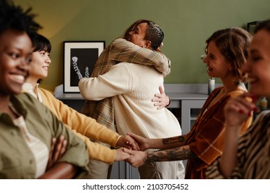 Group of happy friends embracing and greeting each other during their meeting at home - Powered by Shutterstock