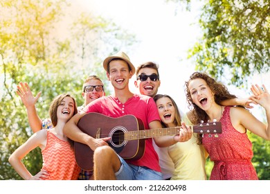 Group Of Happy Friends With Guitar Having Fun Outdoor