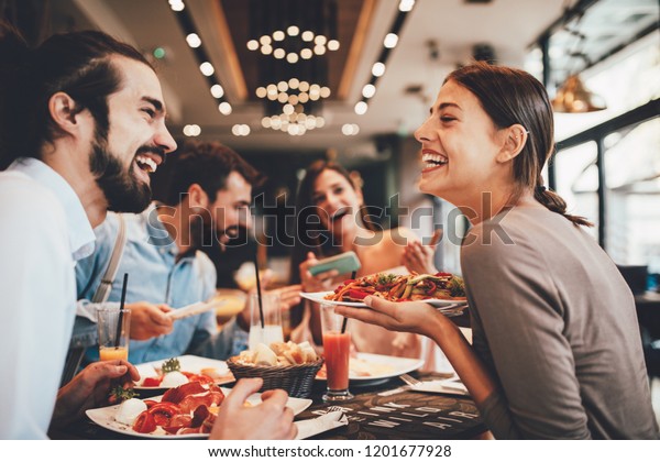 Group\
of Happy friends having breakfast in the\
restaurant