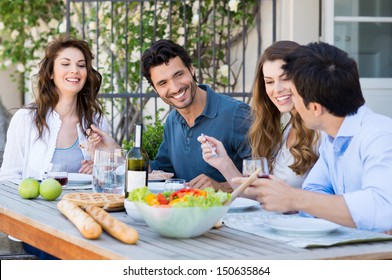 Group Of Happy Friends Having Dinner At Patio