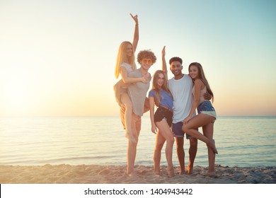 Group of happy friends having fun at ocean beach at dawn - Shutterstock ID 1404943442