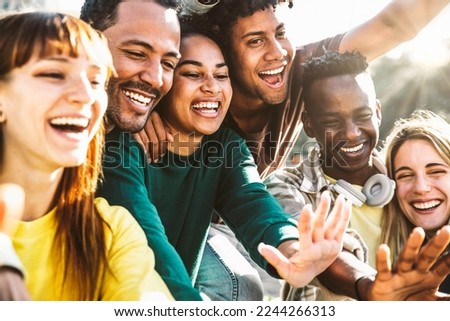 Group of happy friends having fun together walking on city street - Different young people laughing out loud enjoying sunny day out - Friendship concept with guys and girls hangout on a funny weekend 