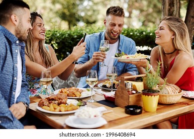 Group of Happy friends having lunch in the restaurant during a sunny summer day - Powered by Shutterstock