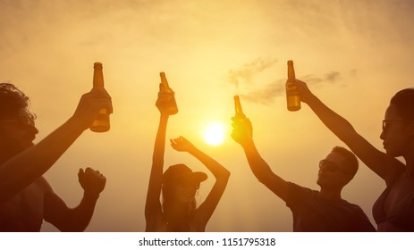 Group Of Happy Friends Having Party Celebrating And Drinking At The Beach On Vacation In Summer Twilight Sunset