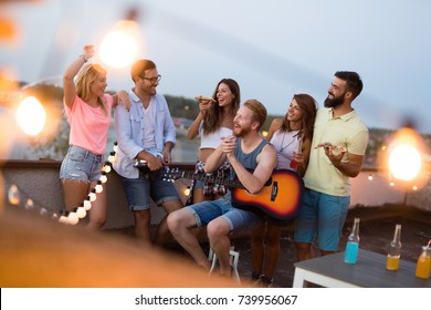 Group Of Happy Friends Having Party On Rooftop