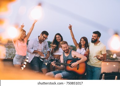 Group Of Happy Friends Having Party On Rooftop