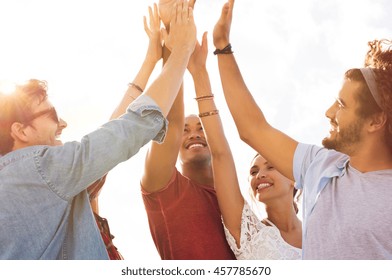 Group Of Happy Friends High Five And Having Fun Together. Mixed Race Guys And Girls Celebrating Success. Cheerful Young Men And Women Giving High Five To Each Other.