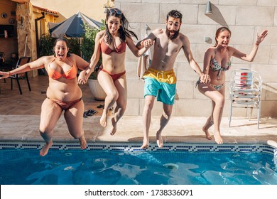 Group Of Happy Friends Holding Hands And Jumping In Pool. Young Diverse Culture People Having Fun In Vacation. Holiday, Youth And Friendship Concept