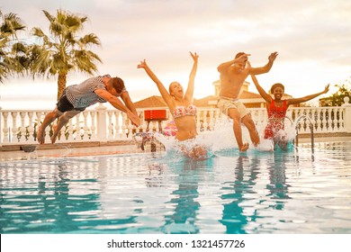 Group Of Happy Friends Jumping Inside Swimming Pool - Young Crazy People Having Fun In Tropical Vacation - Holiday, Youth, Summer Lifestyle And Friendship Concept - Focus On Faces