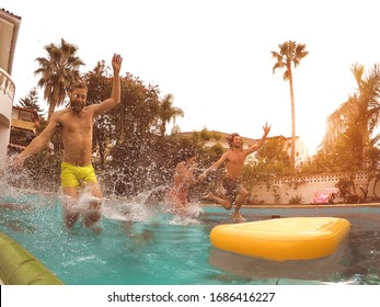 Group Happy Friends Jumping In Pool At Sunset Time - Crazy Young People Having Fun Making Party In Exclusive Tropical House - Summer Vacation And Youth Culture Lifestyle Concept - Focus On Drops