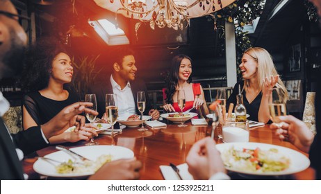 Group Of Happy Friends Meeting And Having Dinner. Celebrating With Friends. Party Dinner Table. Enjoying Meal In Restaurant. Restaurant Chilling Out Classy Lifestyle Reserved Concept.