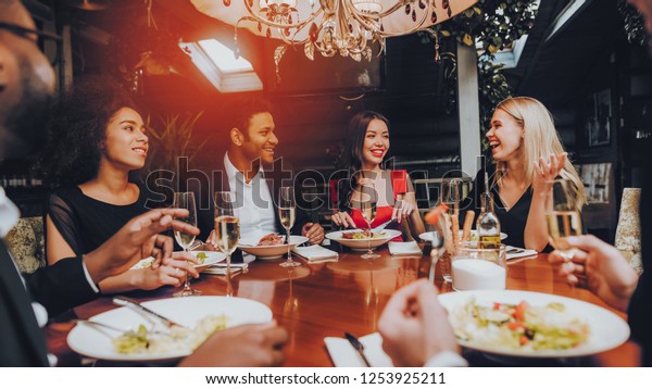 幸せな友達のグループが会って夕食をとる 友達と祝う パーティーディナーテーブル レストランで食事を楽しむ 高級なライフスタイルを 冷やすレストランは 控えめなコンセプト の写真素材 今すぐ編集
