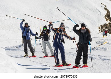 Group Of Happy Friends In The Mountains Snowshoeing