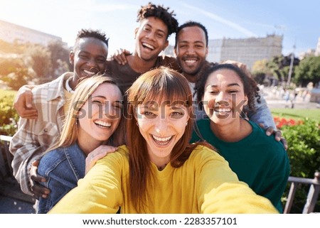 Group of happy friends posing for a selfie on a spring day as they party together outdoors. Group of multicultural friends having a good time together on the weekend.
