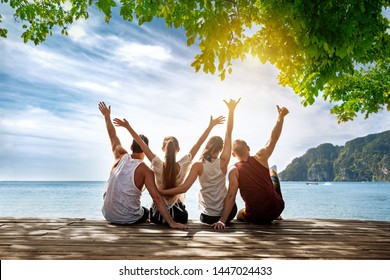 Group Of Happy Friends Is Sitting And Hugging At Idyllic Sea Beach. Phi-phi Island, Krabi, Thailand