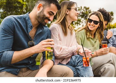 Group of happy friends sitting outdoors and having fun drinking cocktails on plastic glasses - alcohol and people lifestyle concept - Powered by Shutterstock