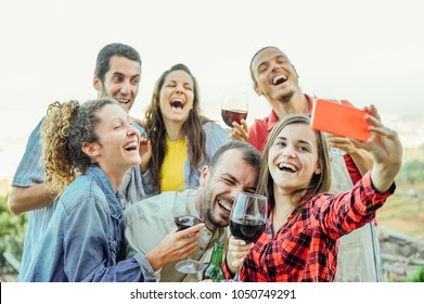 Group of happy friends taking selfie using mobile smart phone camera - Young people having fun a drinking red wine outdoor - Friendship, technology, youth lifestyle concept - Powered by Shutterstock