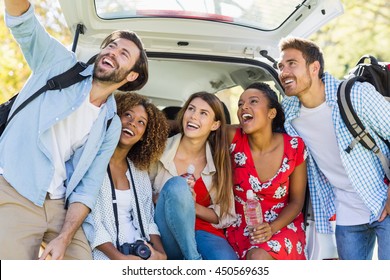 Group of happy friends taking a selfie from trunk of car - Powered by Shutterstock