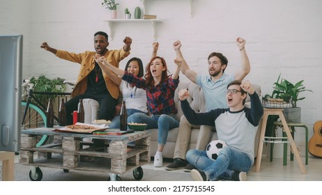 Group of happy friends watching sports game on TV at home indoors. They are happy about their favorite team win competition - Shutterstock ID 2175715545