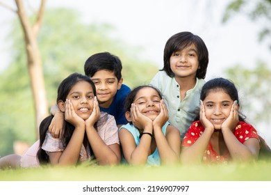 Group of happy Indian children lying on green grass outdoors in spring park, Playful asian kids in the garden. - Shutterstock ID 2196907997