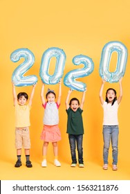 Group Of Happy Kids Celebrating And Showing 2020 New Year Concepts