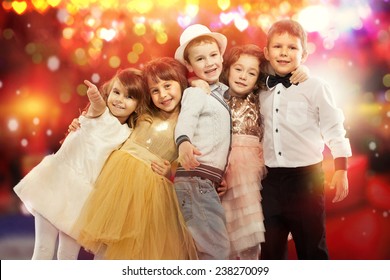 Group of happy kids in celebratory clothes with colorful lights on background. Holidays, christmas, new year, x-mas concept. - Powered by Shutterstock