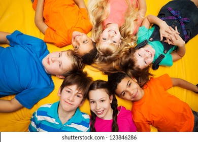 Group Of Happy Kids Laying In Circle - Diversity Looking Caucasian And Black Boys And Girls Smilng