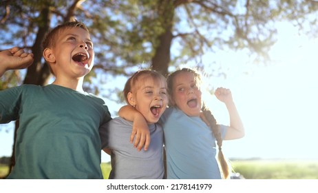 group of happy kids in the park. a team of small children hugging rejoice shouting fun in the forest park. happy family victory kid concept. a group of kids rejoice in victory dream in forest park - Powered by Shutterstock