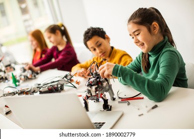 Group Of Happy Kids Programming Electric Toys And Robots At Robotics Classroom