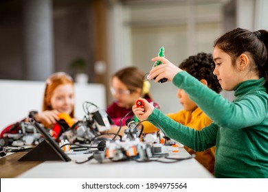 Group Of Happy Kids Programming Electric Toys And Robots At Robotics Classroom