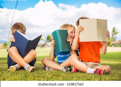 Group Of Happy Kids Reading Books Outside, Friendship And Learning Concept