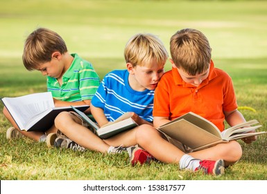 Group Of Happy Kids Reading Books Outside, Friendship And Learning Concept