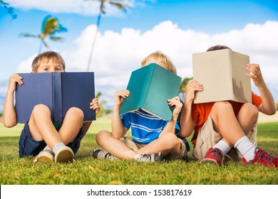 Group Of Happy Kids Reading Books Outside, Friendship And Learning Concept