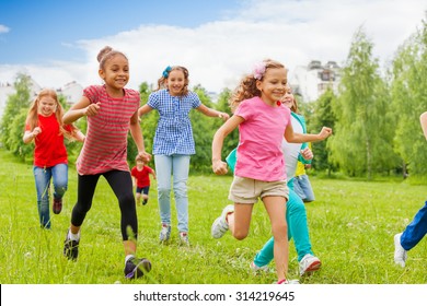 Group Of Happy Kids Running Through Green Field