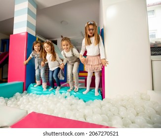 Group Of Happy Little Girls Jumping Into Ball Pit