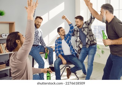 Group of happy male friends celebrating meeting at home. Laughing men drinking beer, talking to each other, celebrating victory of their favorite team at home. Meeting of best friends, soccer fans - Powered by Shutterstock