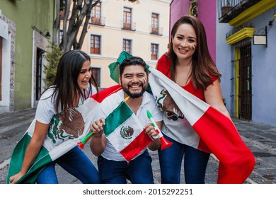 Group Of Happy Mexican People Holding Flags At Mexican Party