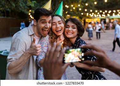 Group Of Happy Multhiethnic Friends Celebrating With A Cake Outdoors, Taking Picture With Photo Camera