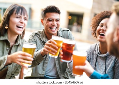 Group Of Happy Multiethnic Friends Drinking And Toasting Beer At Brewery Bar Restaurant - Beverage Concept With Men And Women Having Fun Together Outside - Bright Warm Filter With Focus On Asian Guy