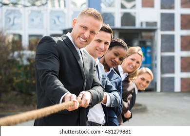 Group Of Happy Multiethnic People Playing Tug Of War