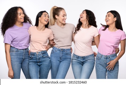 Group Of Happy Multiethnic Women Hugging Laughing Standing Together Over White Studio Background, Smiling Each Other. Female Friendship And Togetherness, Diversity And Unity Concept.