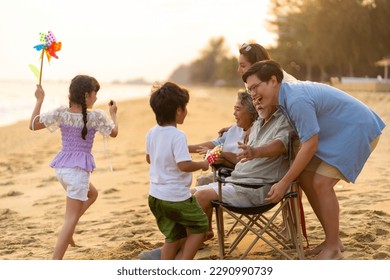 Group of Happy Multi-Generation Asian family enjoy and fun outdoor activity lifestyle resting and playing together at tropical island beach during travel ocean at sunset on summer holiday vacation. - Powered by Shutterstock