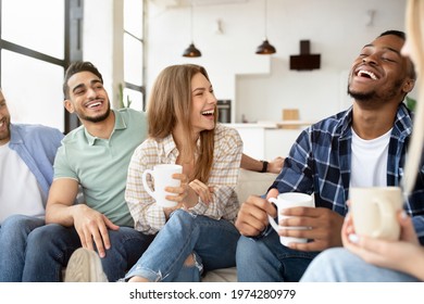 Group of happy multiracial friends drinking coffee in living room, having conversation, enjoying time together. Diverse fellows having home party, joking and laughing - Powered by Shutterstock