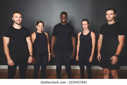 A Group happy muscular female and male adults standing together as good friends in gym black background - Powered by Shutterstock