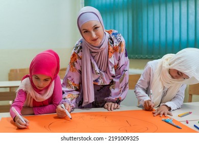 Group of happy Muslim school kids with their teacher working on project together at classroom. - Powered by Shutterstock