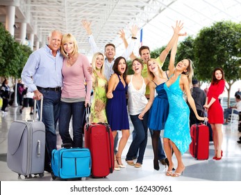 Group Of Happy People In Airport. Holiday Travel Background.