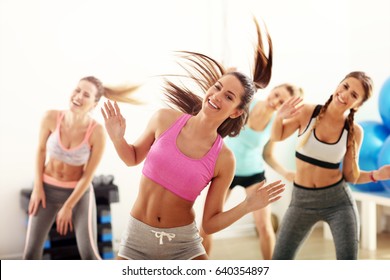 Group of happy people with coach dancing in gym - Powered by Shutterstock